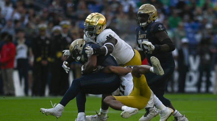 Notre Dame safety Ramon Henderson (11) and Irish linebacker Marist Liufau (8) tackle Navy fullback Daba Fofana.